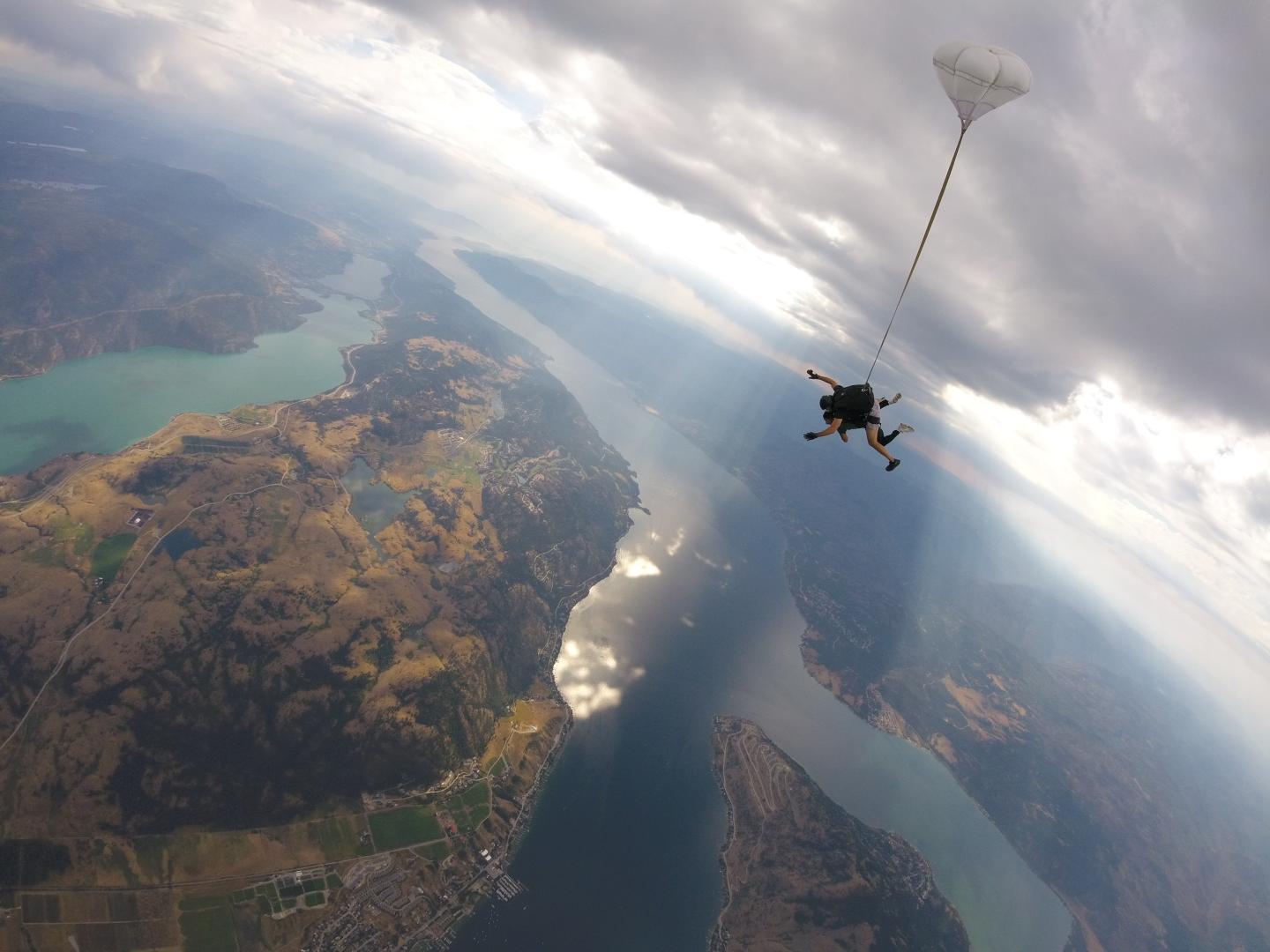 An aerial view of sky divers over lakes and mountains