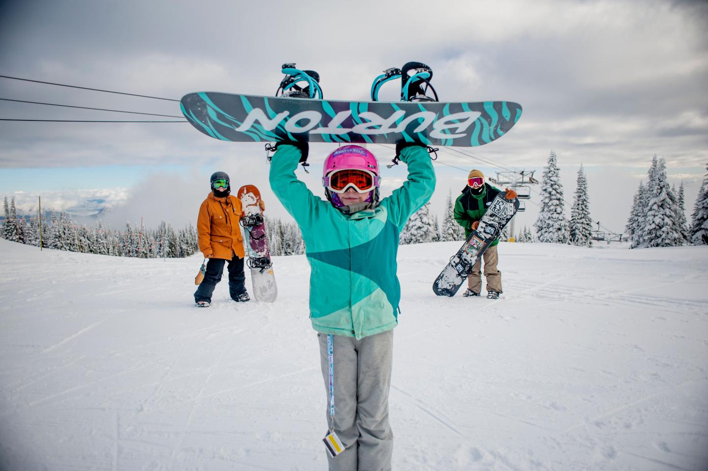A family pose for a photo while snowboarding