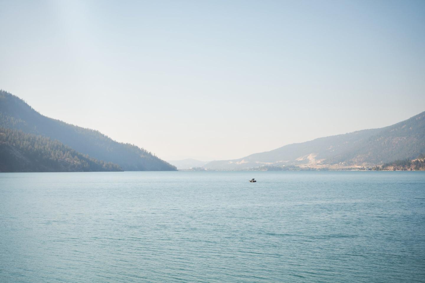 mountain lake with boat in the distance