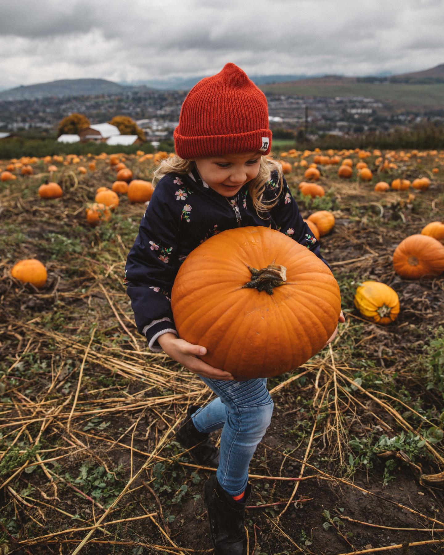 A child carrying a pumpkin