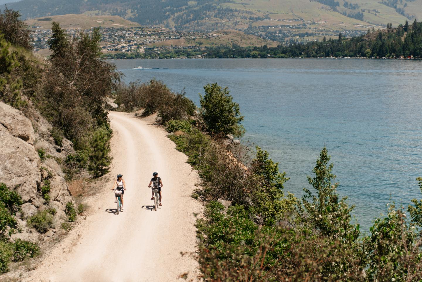 Two people biking along a lake