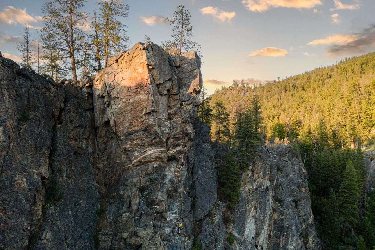 cliff in the mountains with sun coming over the top