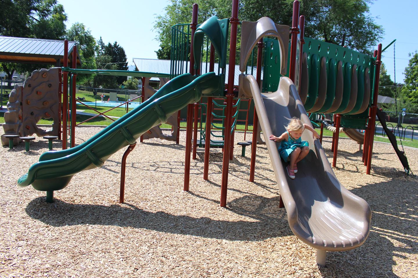 kid playing on slide in playground