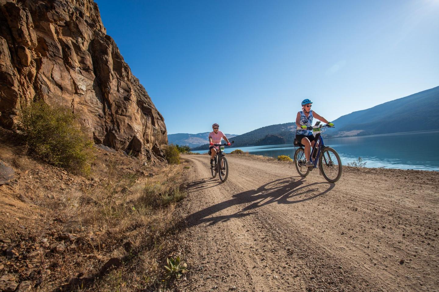 people on bikes beside lake