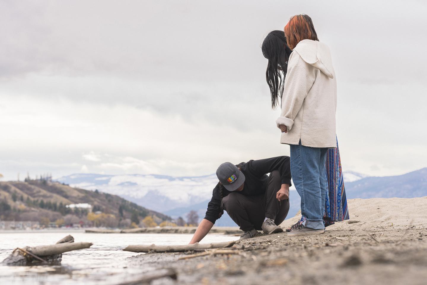 indigenous people at lake connecting with water