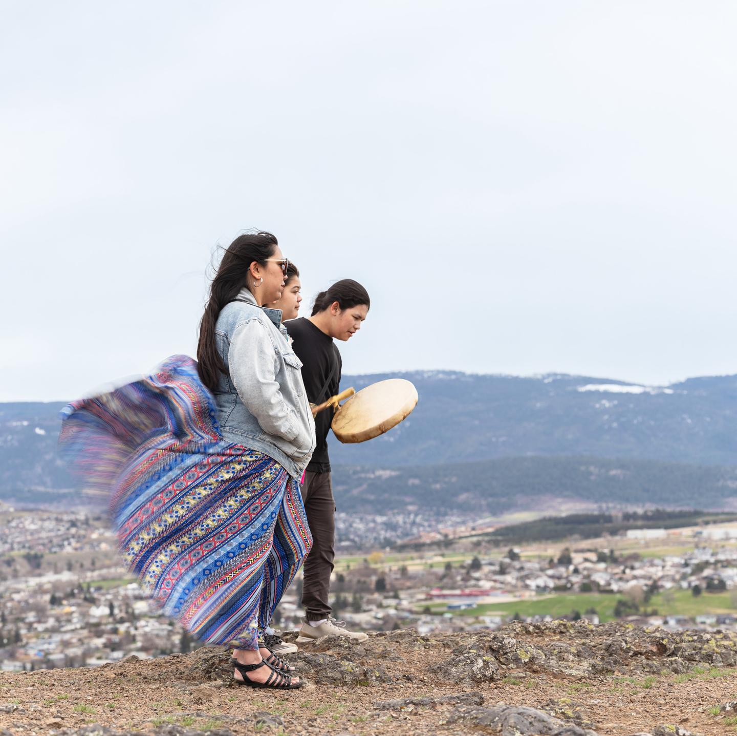 indigenous people drumming on hillside