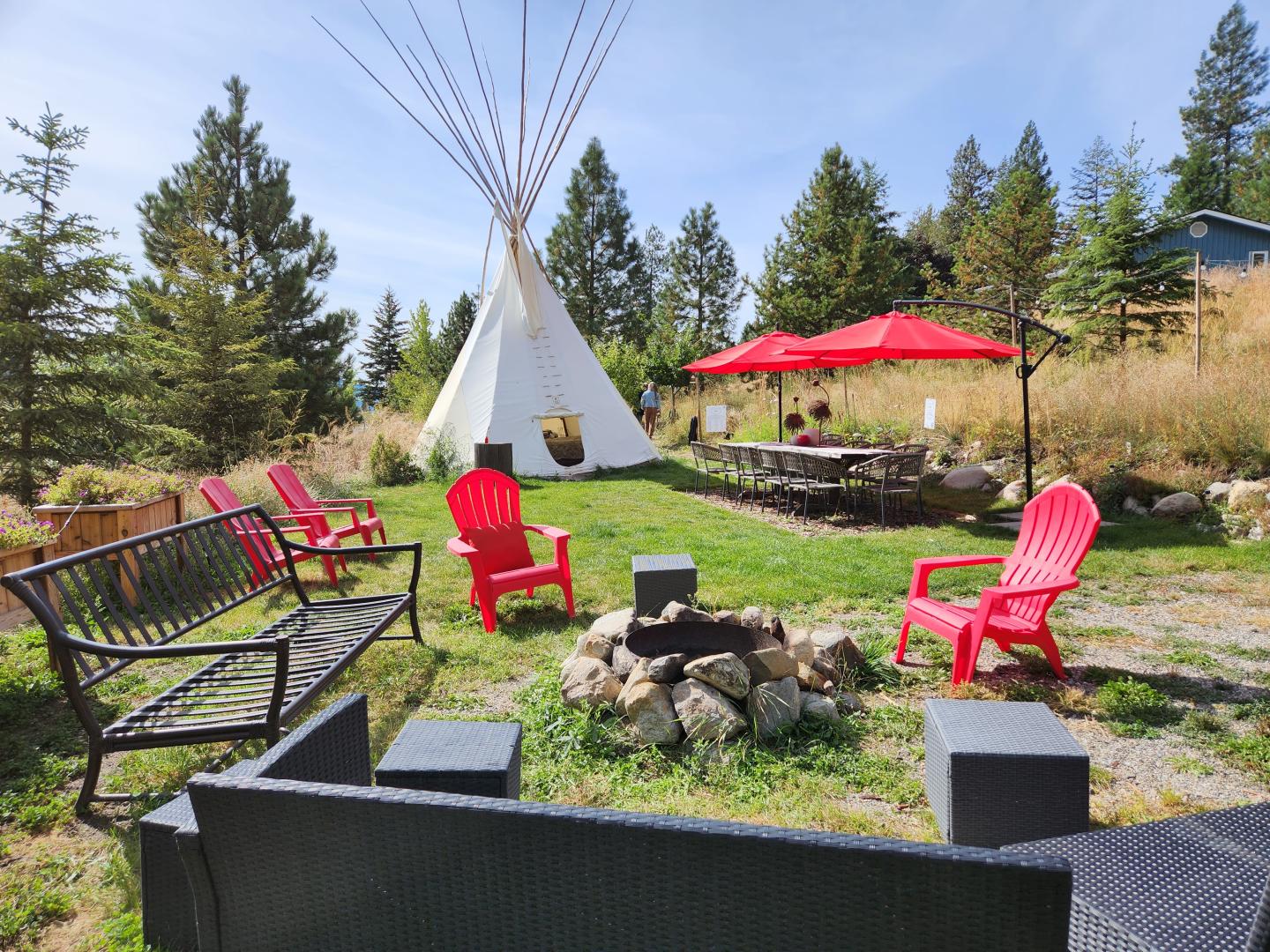 Chairs around campfire with teepee in background