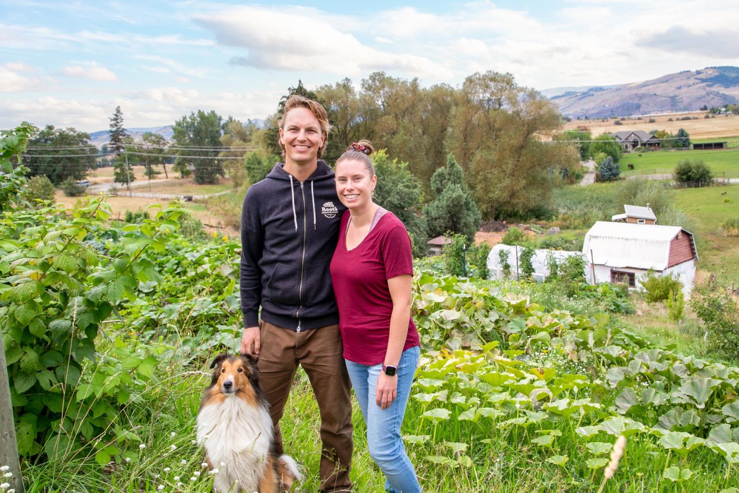 couple of farmers with dog on their family farm