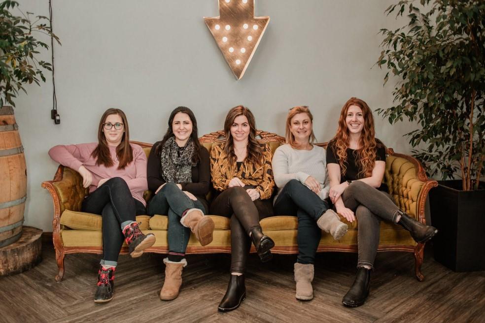 women lined up on couch smiling