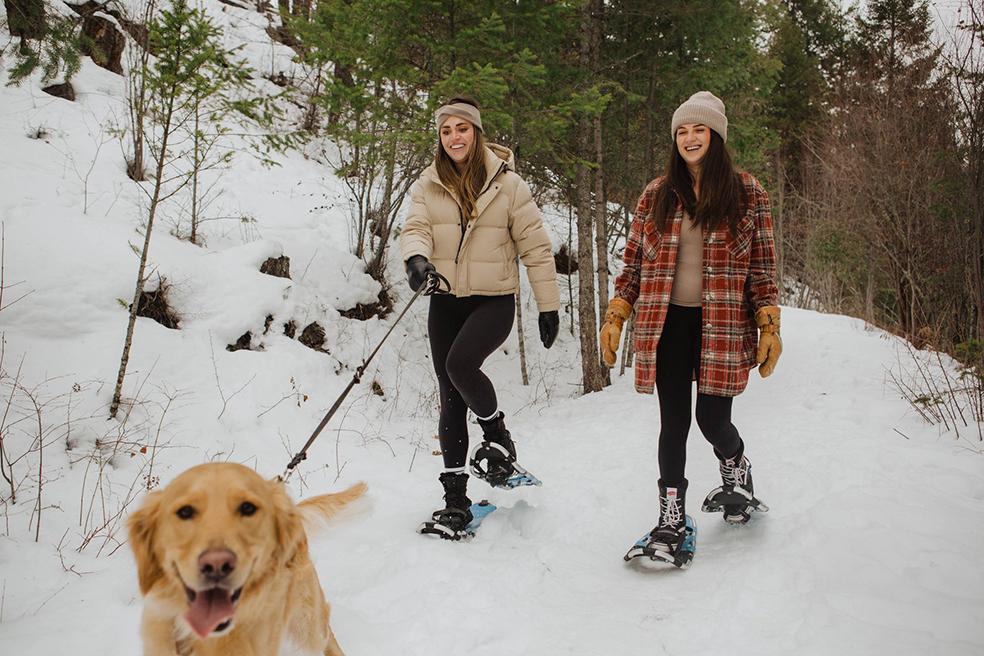 friends snowshoeing with dog