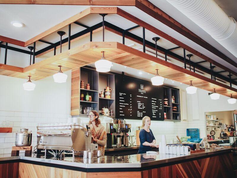 Two female baristas behind the counter inside Triumph Coffee
