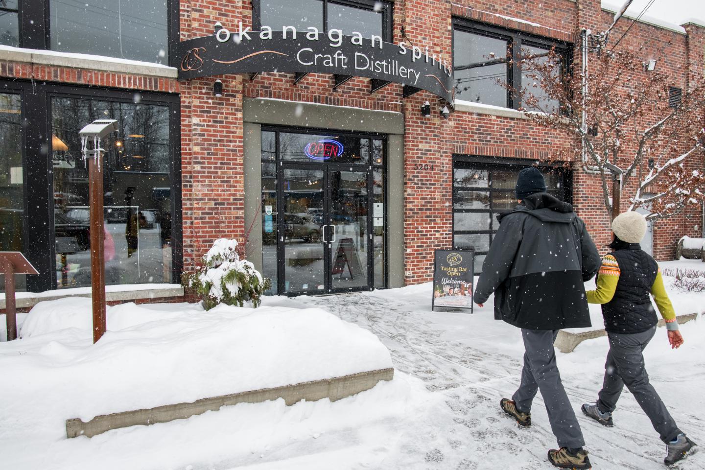 couple walking into distillery in the winter