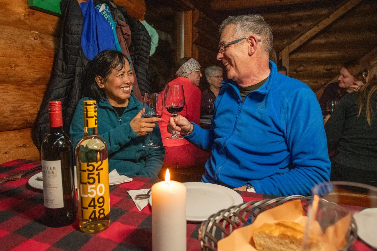 couple toasting wine at dinner in a cabin
