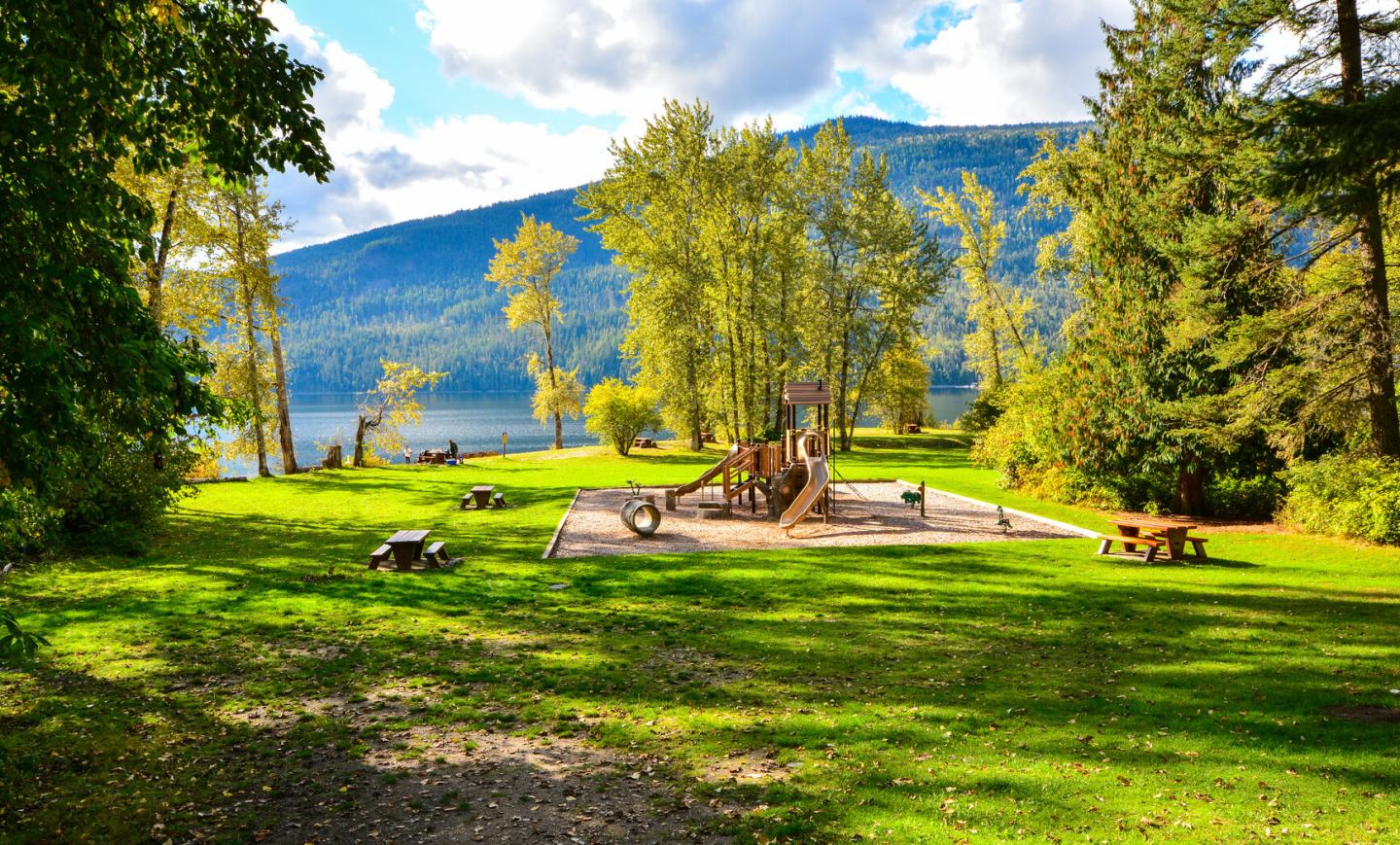 playground in grassy area next to the lake
