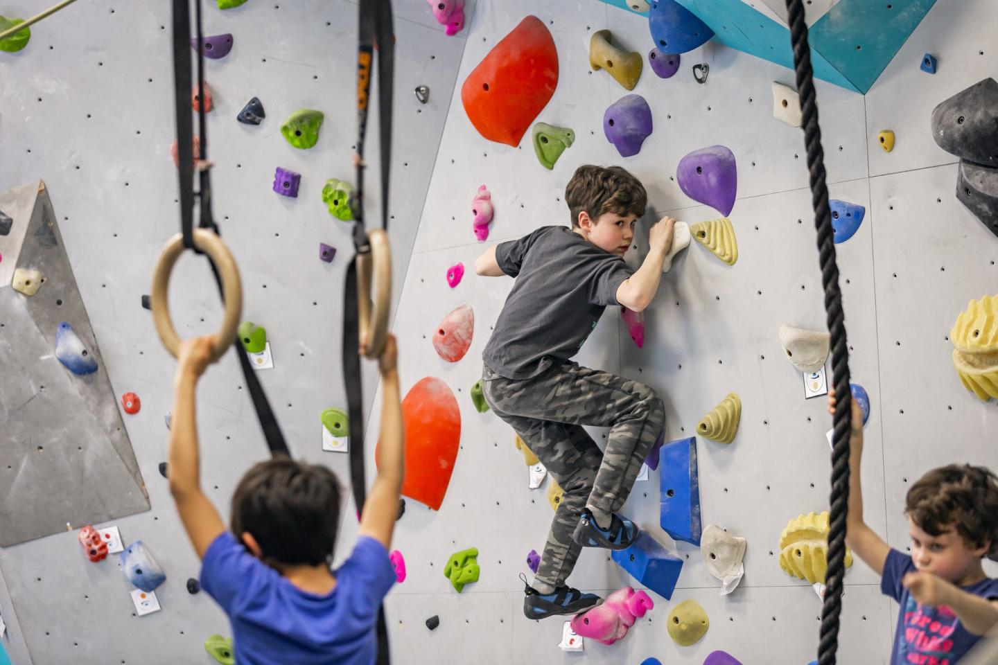 Kids rock climing on indoor rock climbing wall