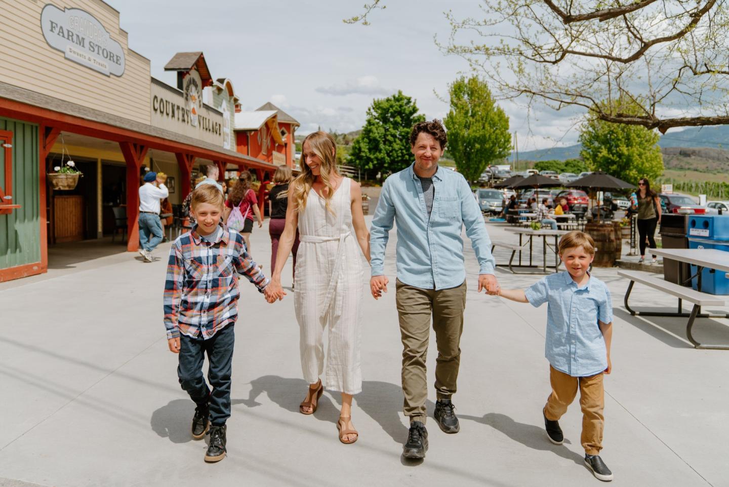 Family walking hand in hand through Davison Orchards in Vernon BC