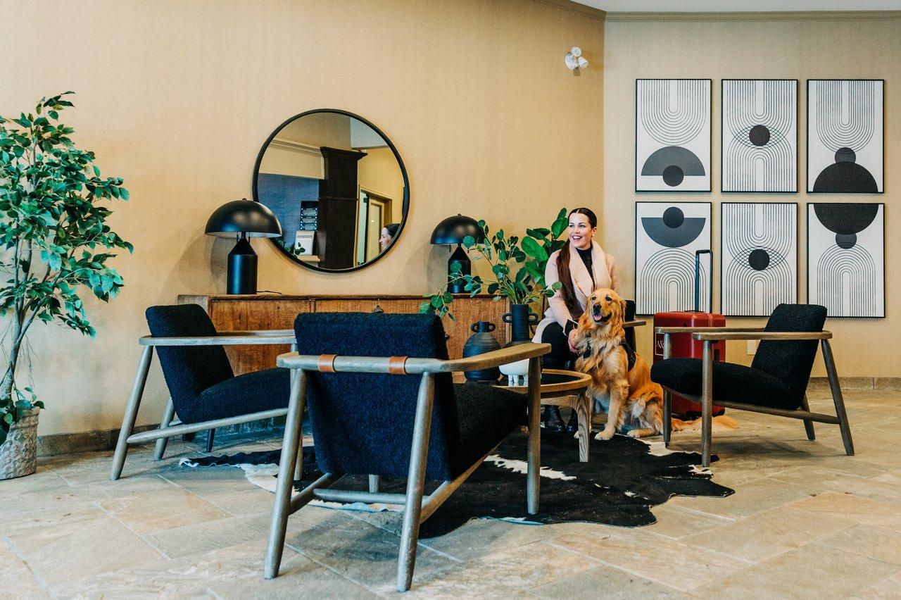 women and dog sitting in hotel lobby