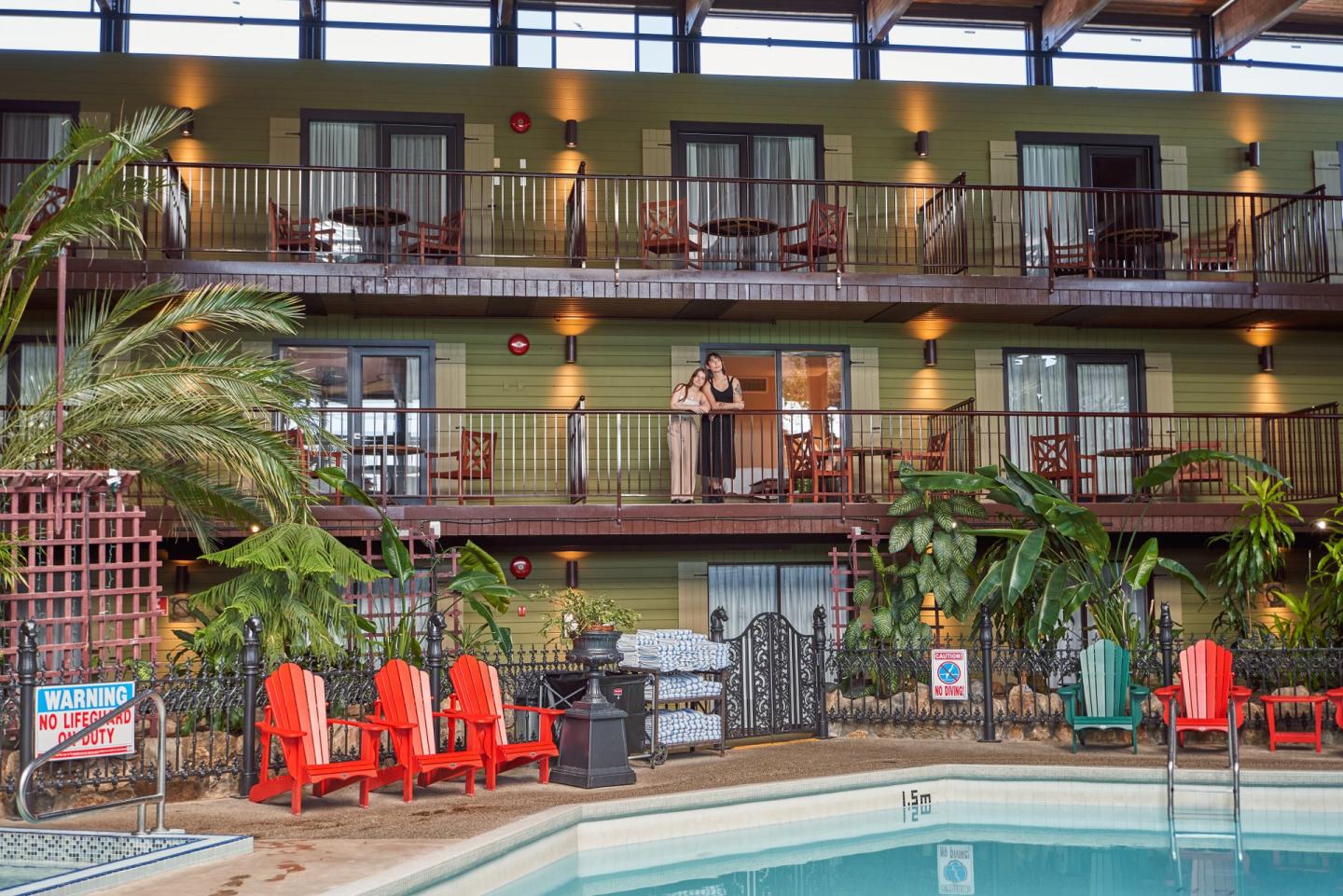 Interior Atrium of Hotel with Pool and couple looking down from the balcony