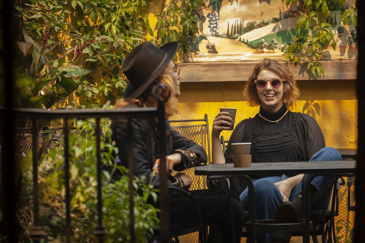 Two people enjoying coffee on the patio at The Bean Scene
