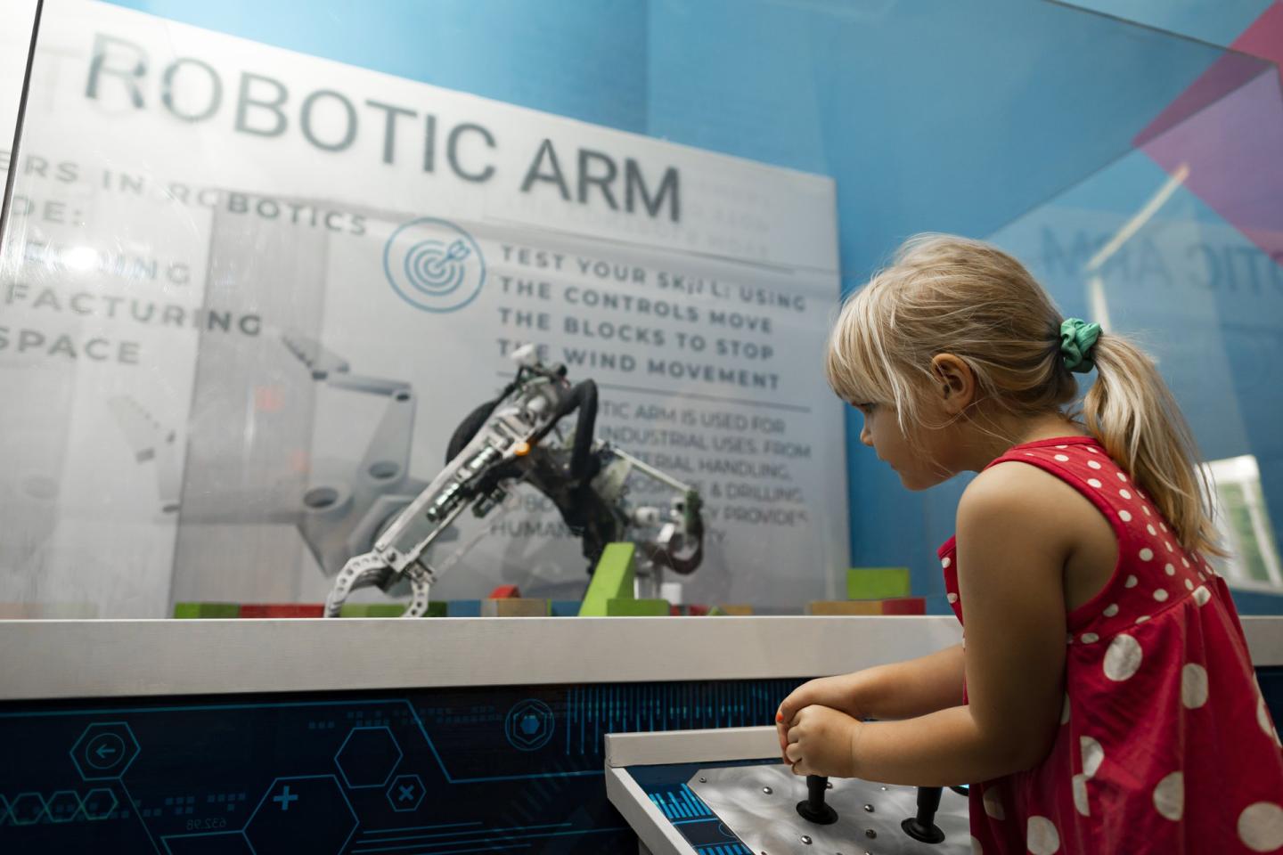 Little girl playing with the robotic arm at the Okanagan Science Centre