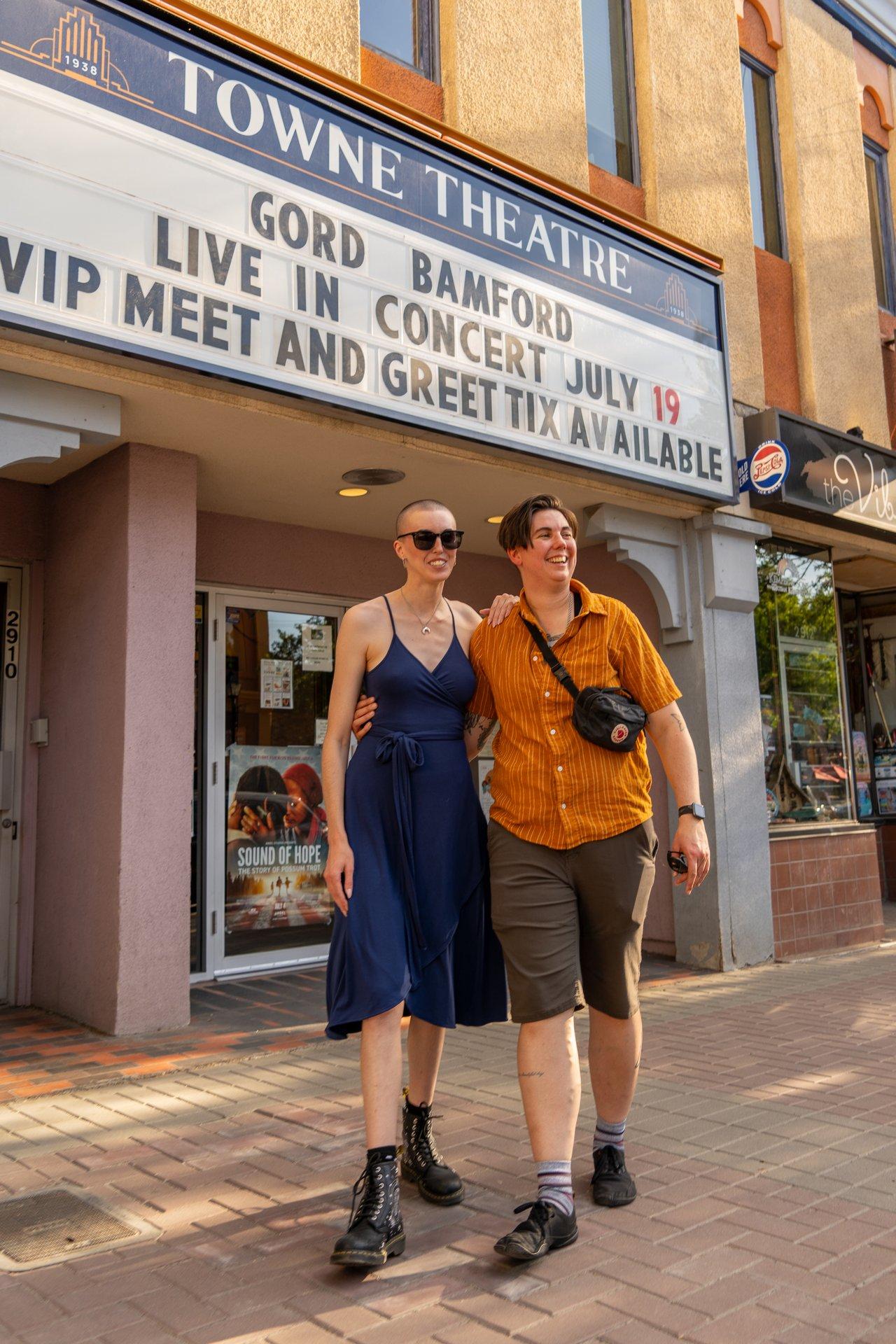 couple standing in front of a theatre marquee
