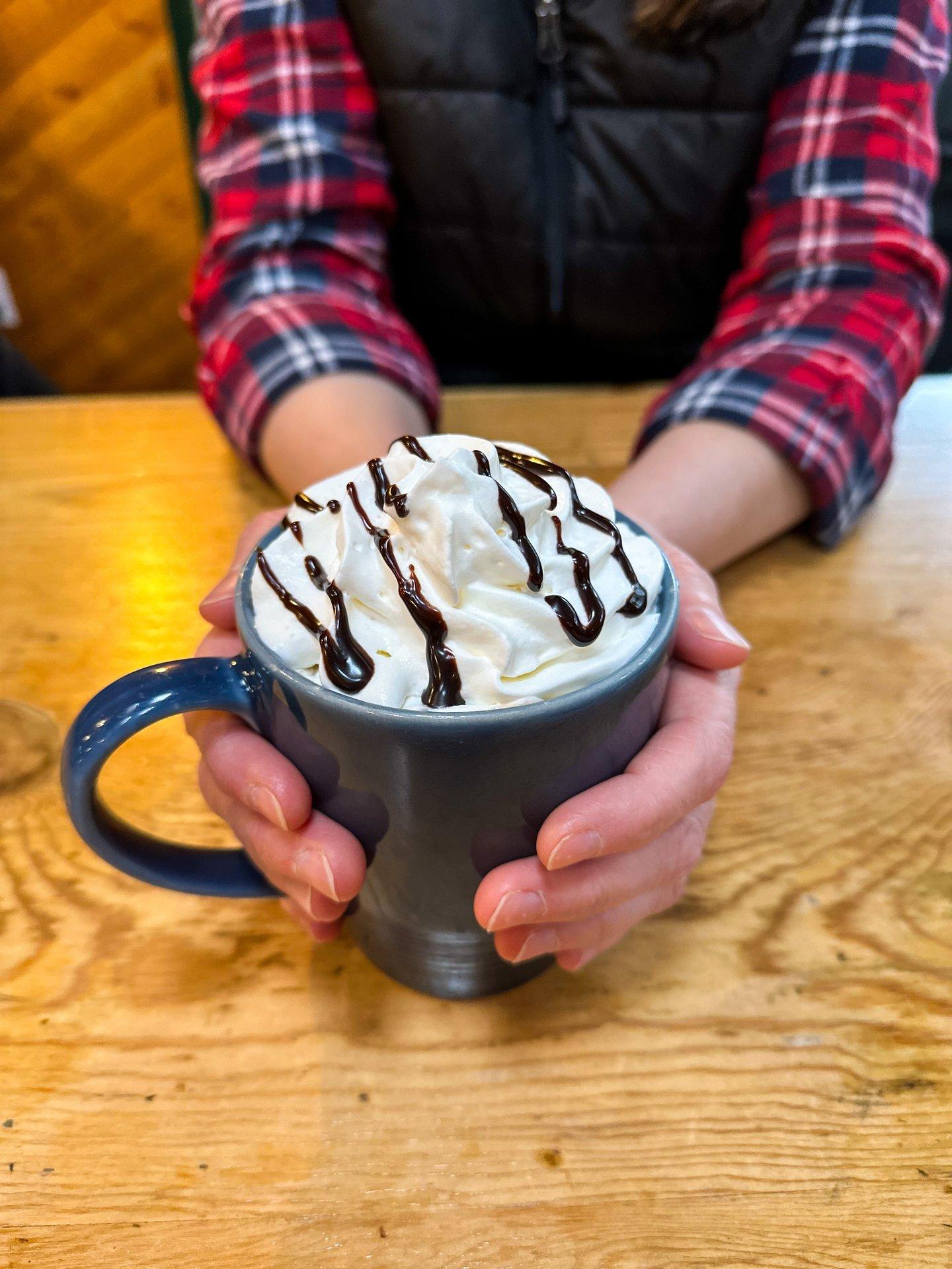 hands holding a mocha at cafe
