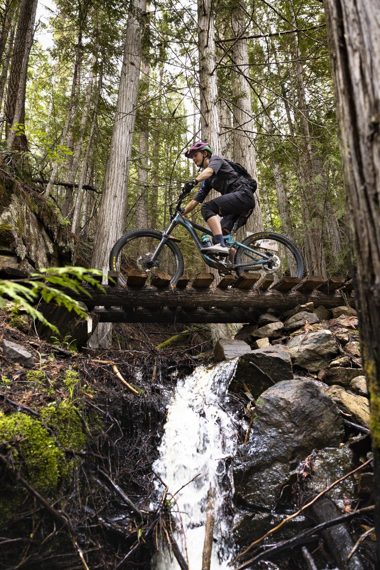 mountain biking on bridge over waterfall