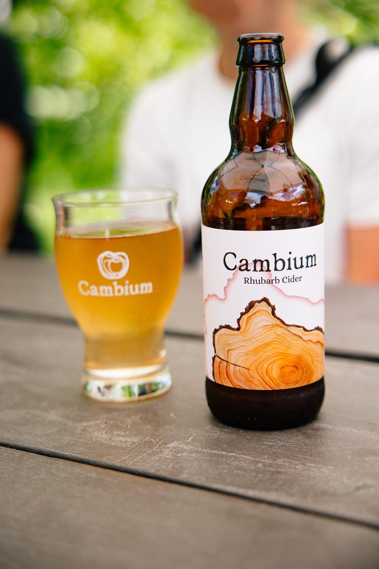 a bottle of cider next to a glass of cider