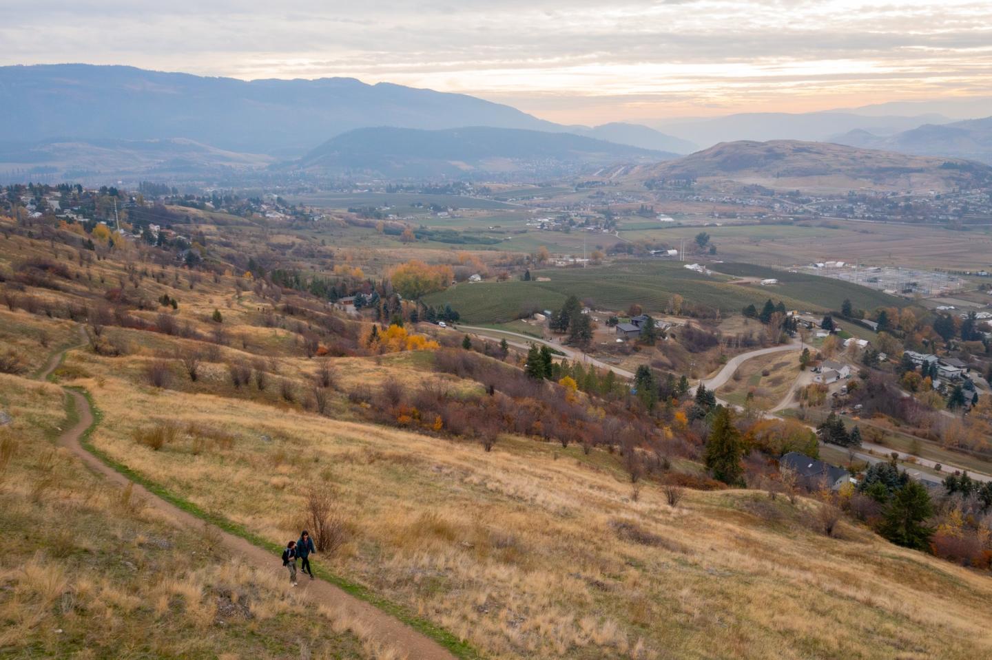drone shot of fall view of mountains and lakes with people walking