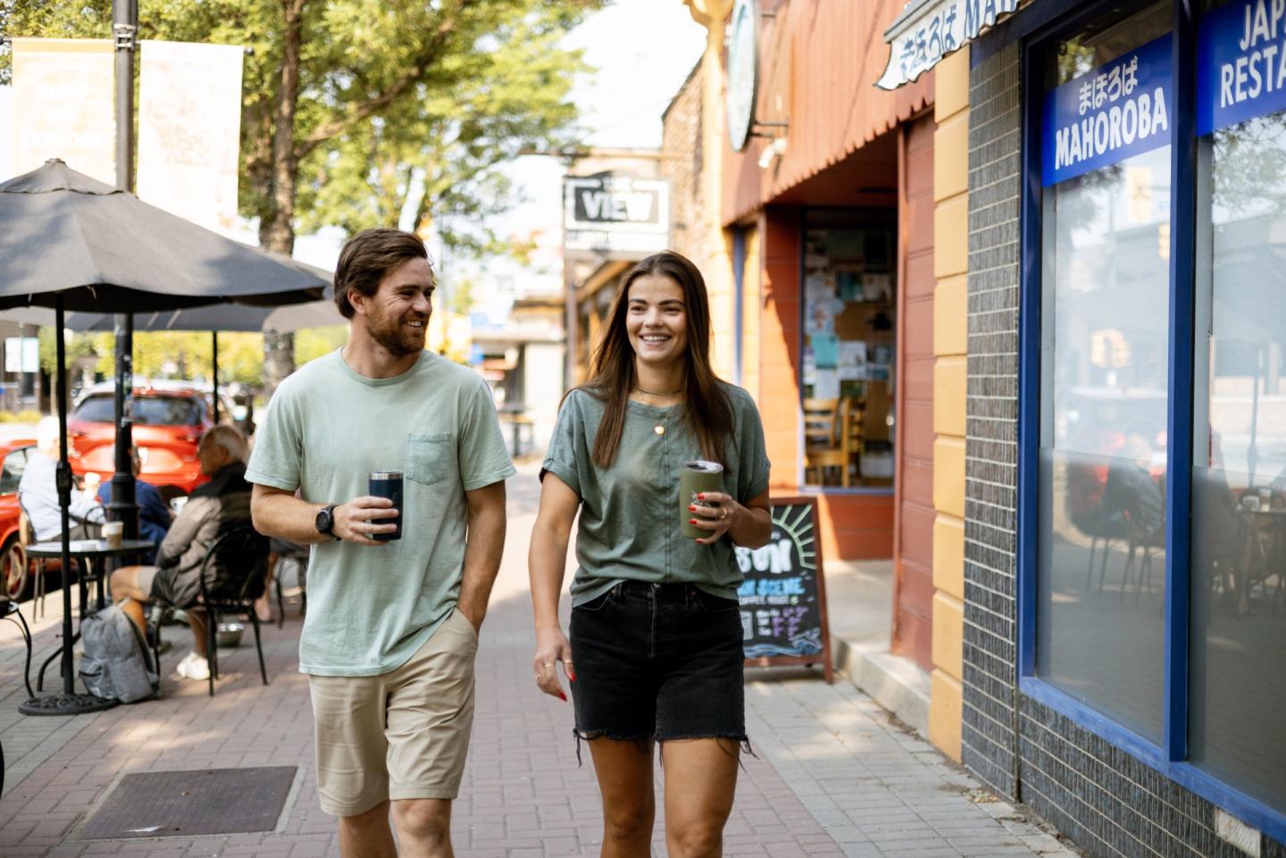 two people walking downtown on the sidewalk