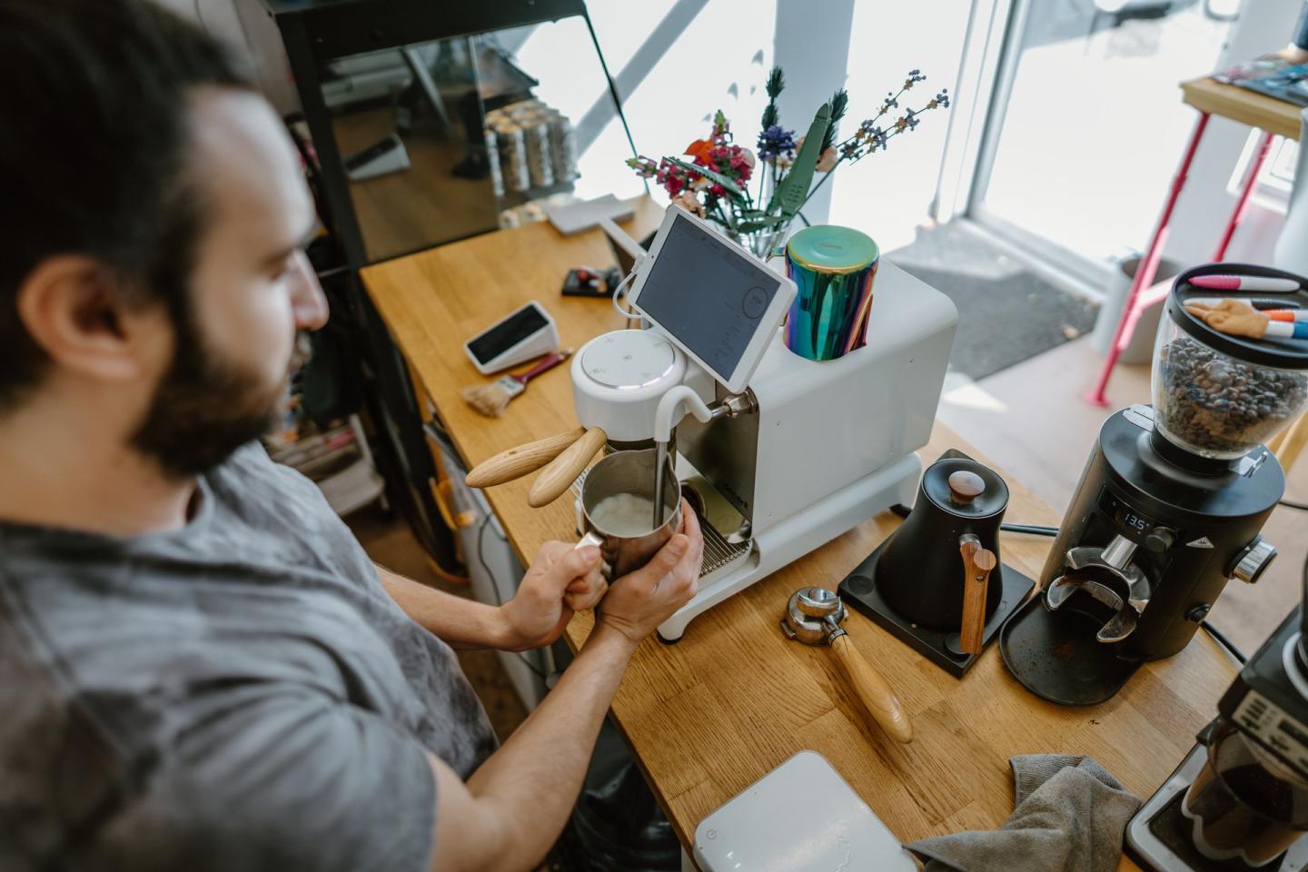 person making coffee in espresso machine at shop