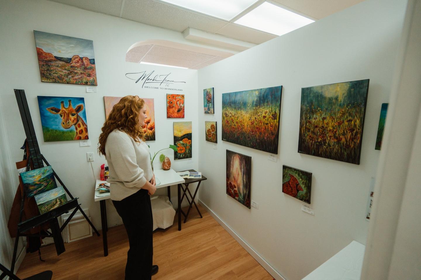 woman looking at paintings at art gallery