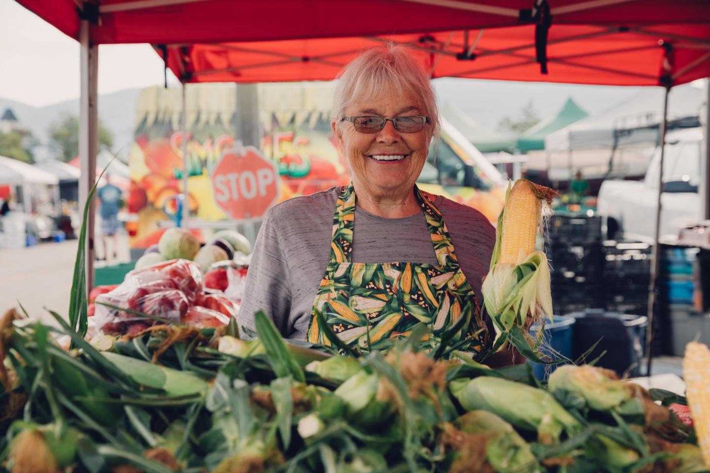 Lady holding corn at farmers market