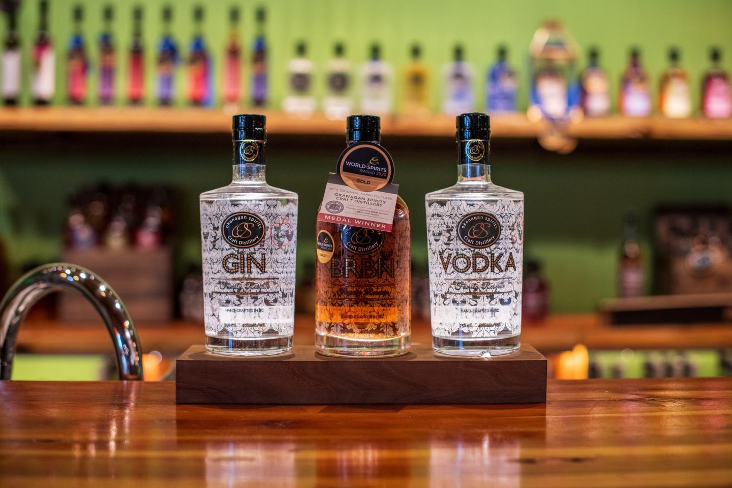 bottles of gin, vodka and whisky sitting on a bar