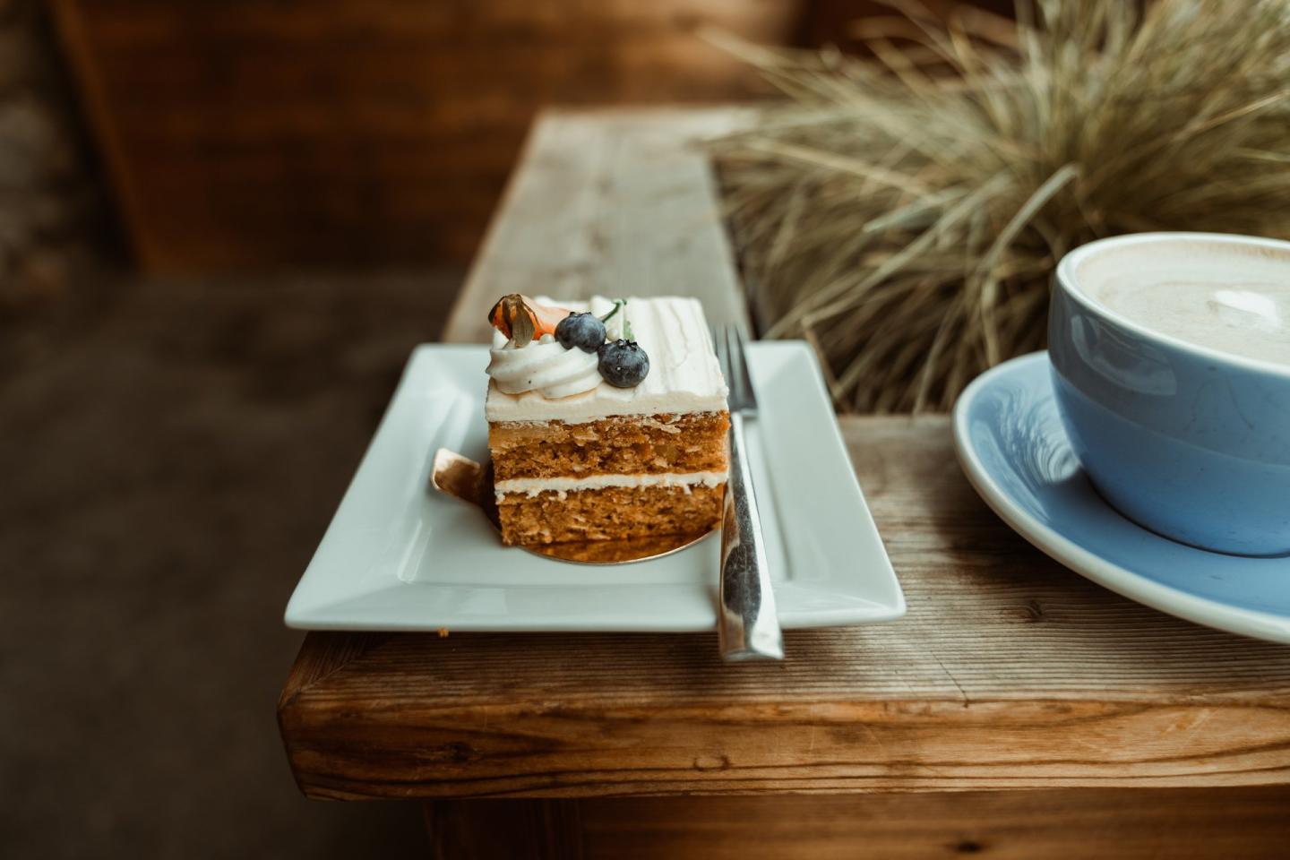 coffee and cake sitting on a table on a patio