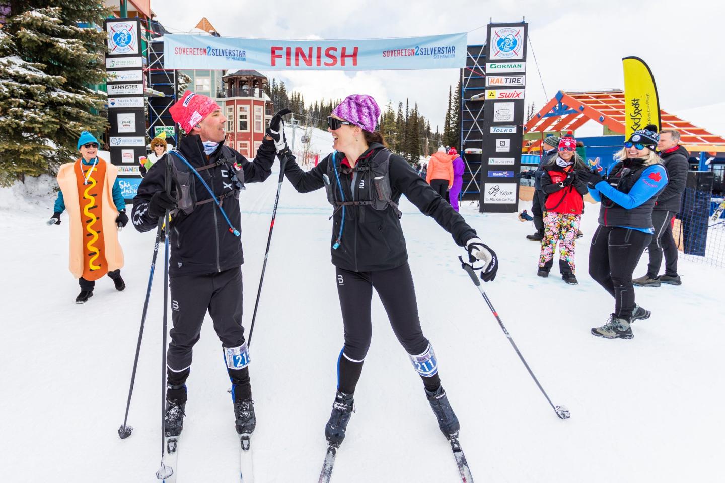 two people high fiving from finishing a cross-country ski race