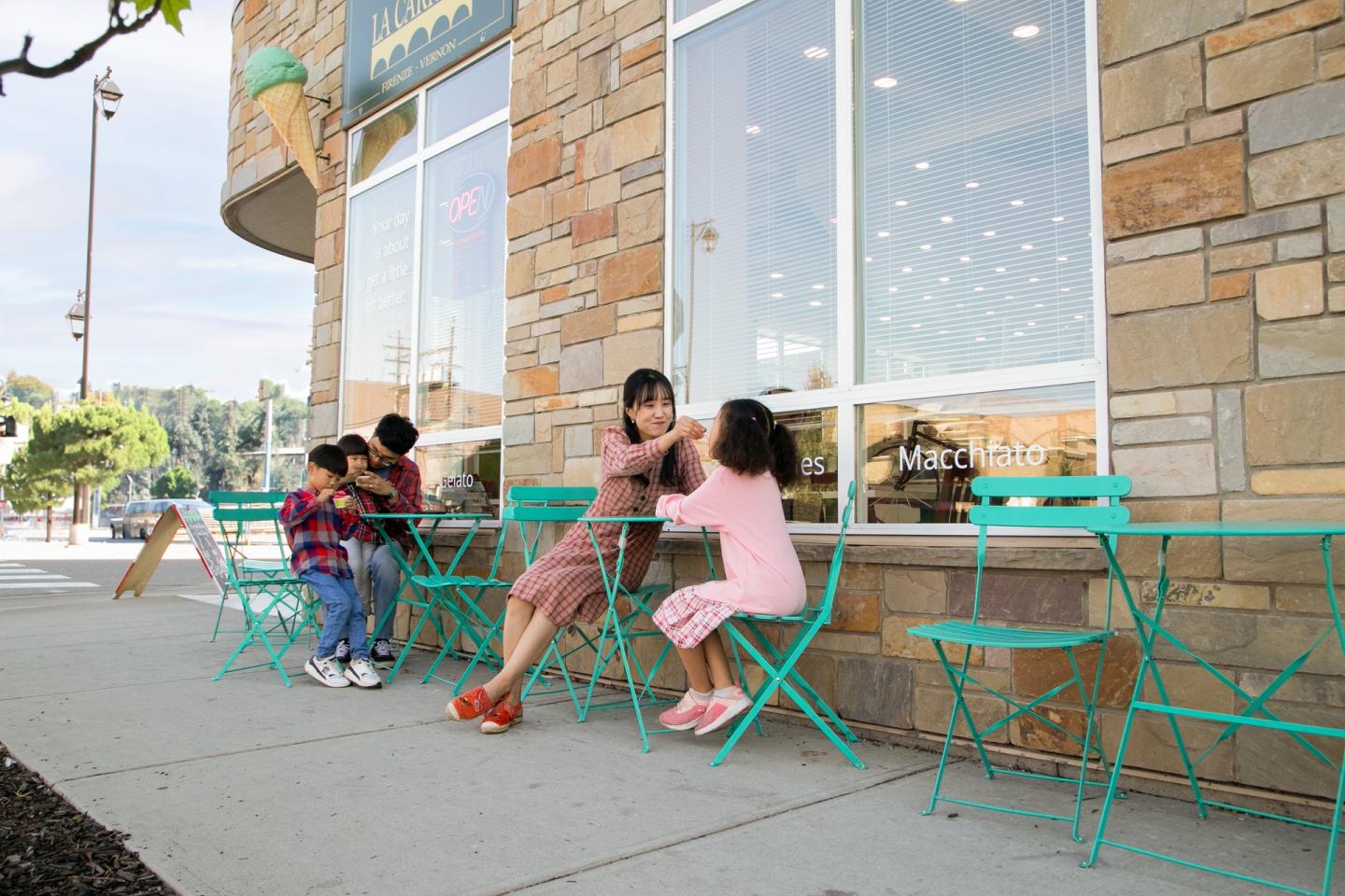family eating ice cream on street side patio