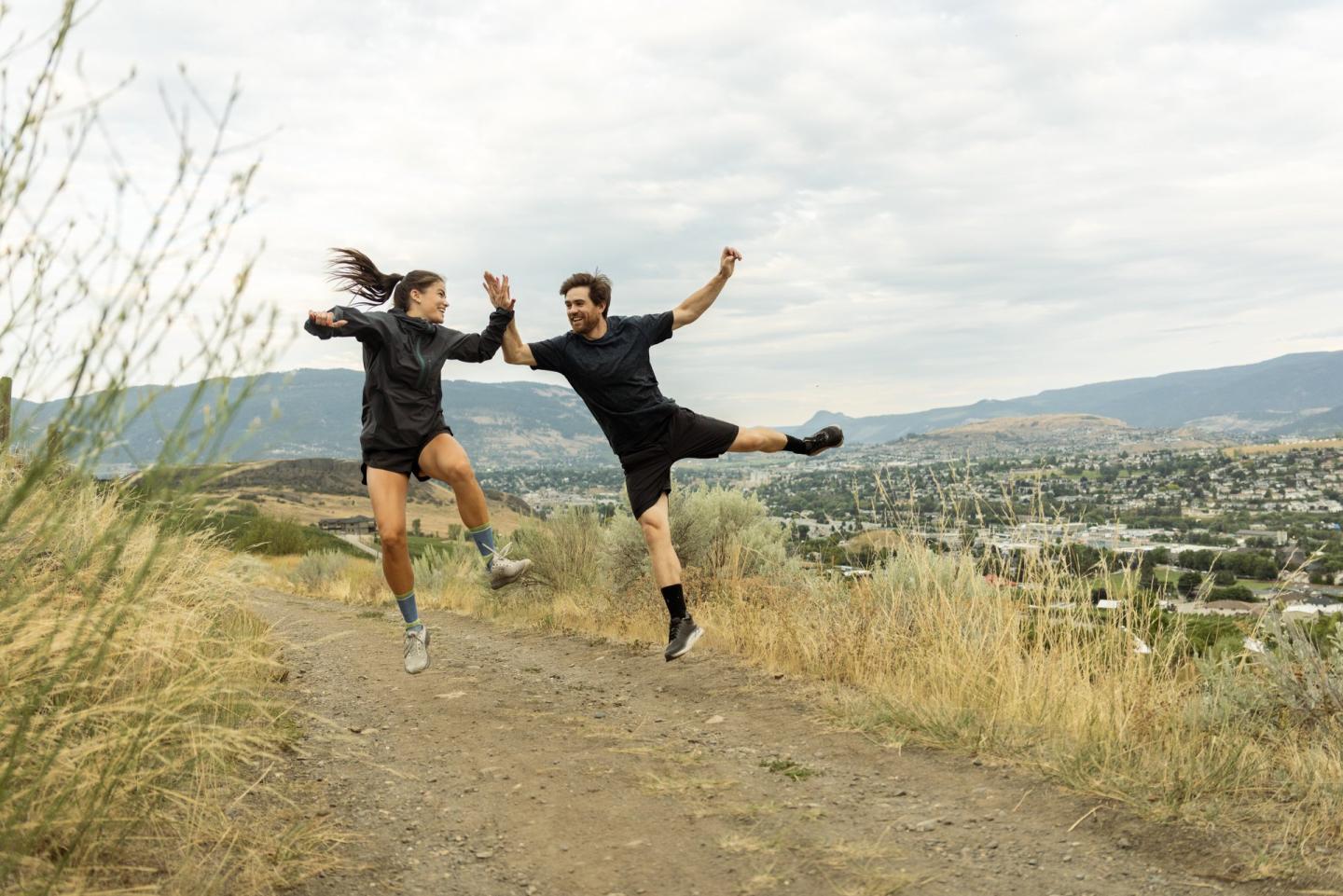two people high fiving while hiking on a trail in Vernon, BC