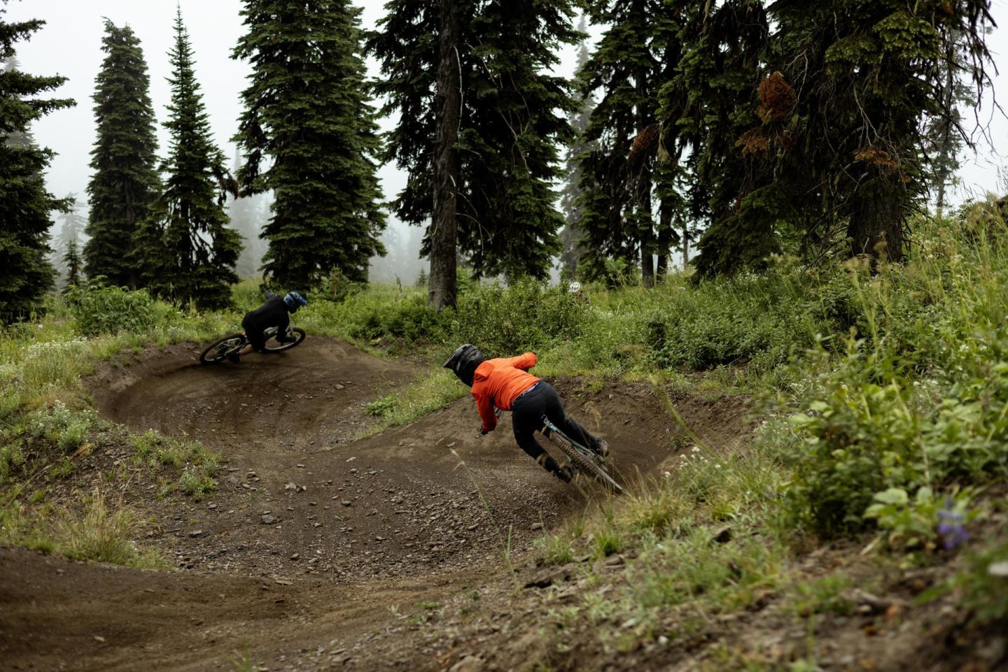 two mountain bikers riding berms at a bike park
