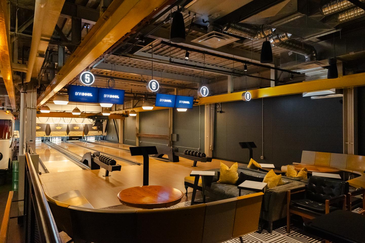 BNA bowling alley with lanes, seating, and overhead scoreboards.