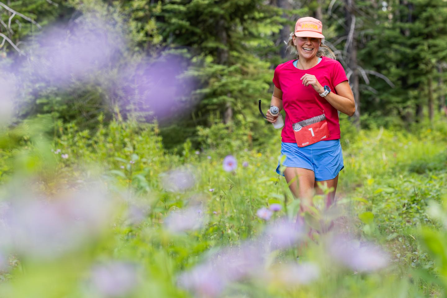 Woman running in the mountains through wildflowers 