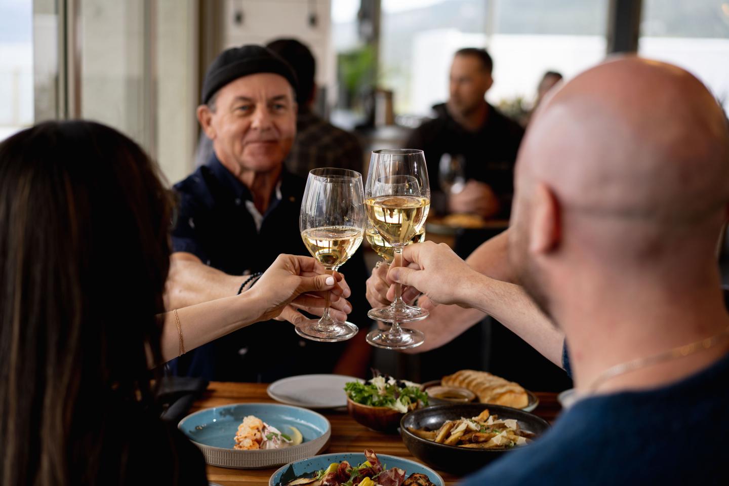 A group of 4 toasting to their dinner at the Lookout Restaurant at Gray Monk Winery/