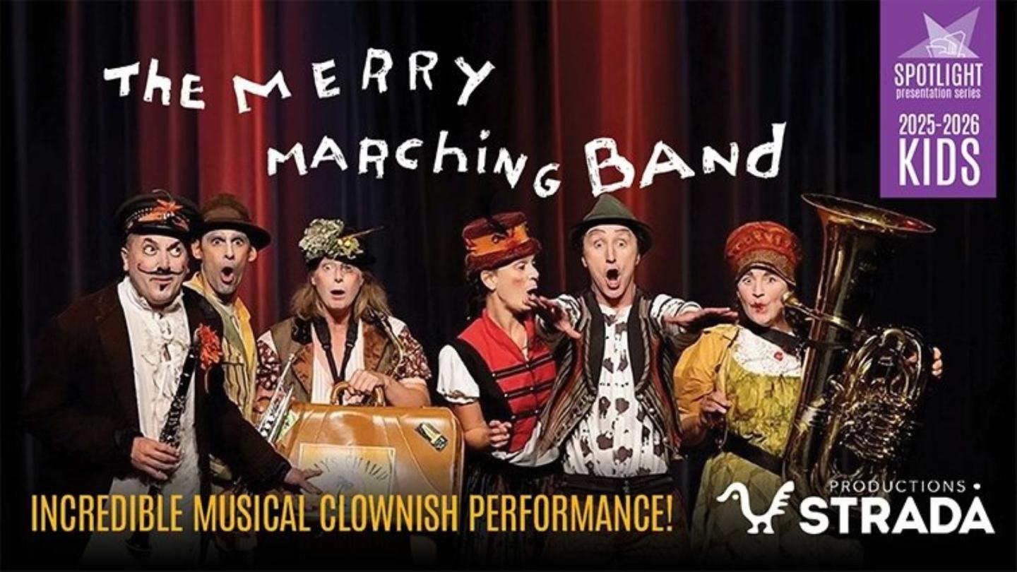 Five performers in colorful costumes with brass instruments on stage.