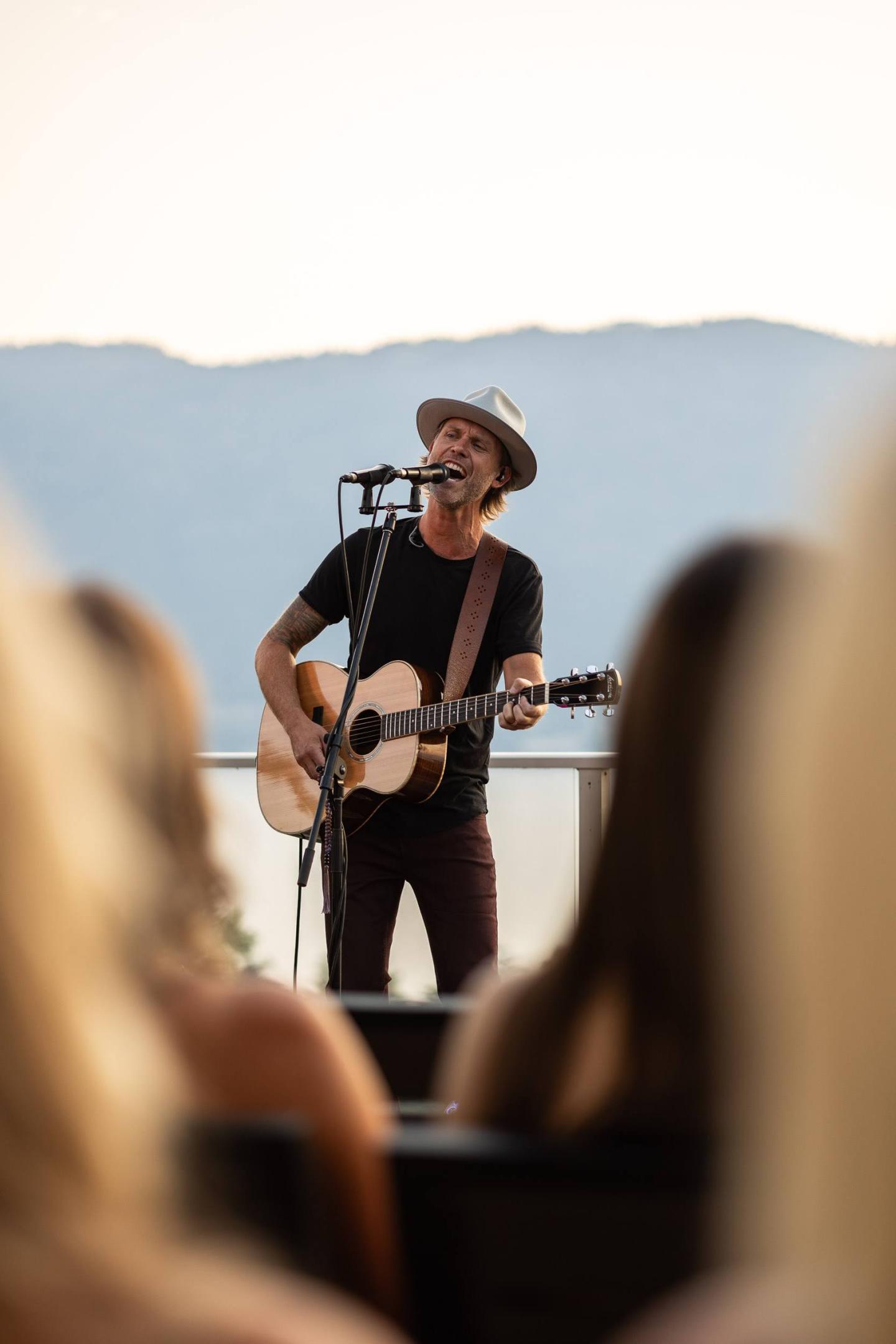 Andrew Allen singing at the Lookout with mountains in the background