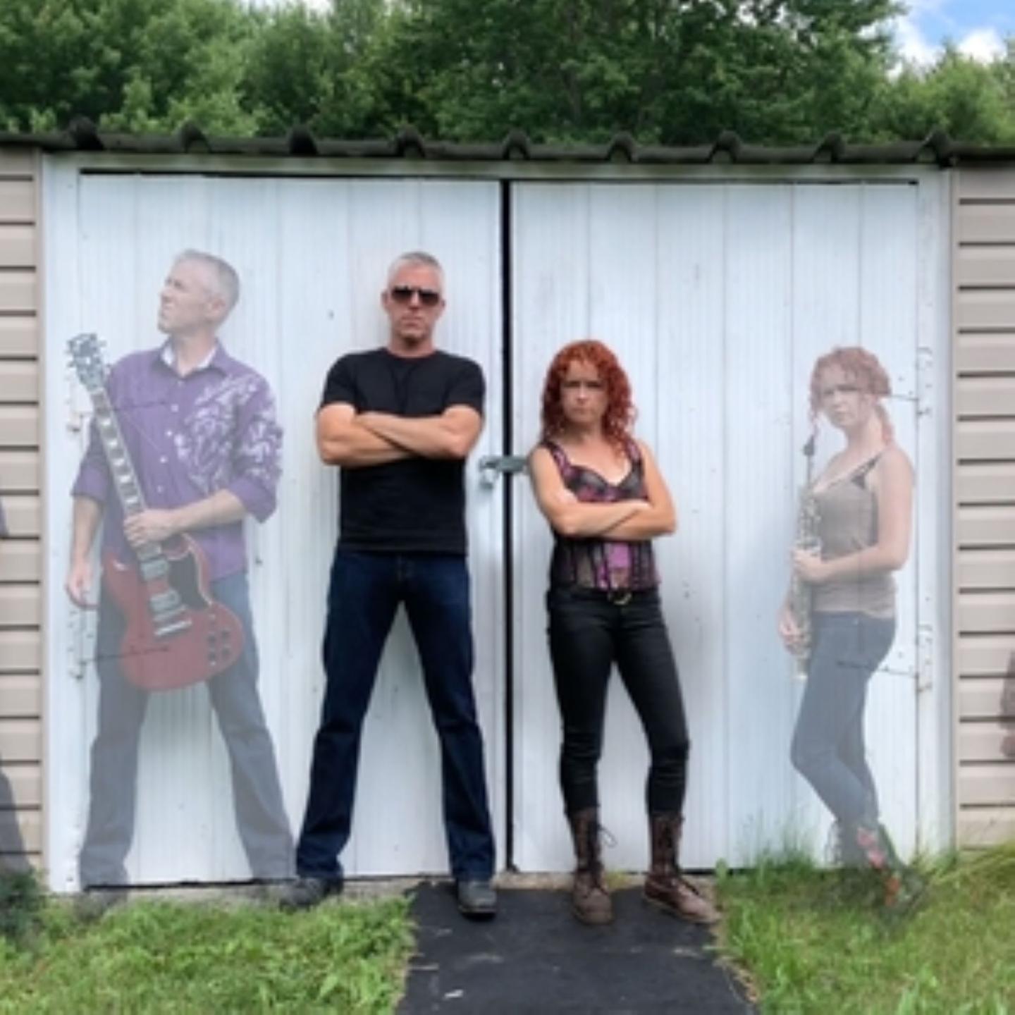 Two people stand confidently, arms crossed, in front of a white shed.