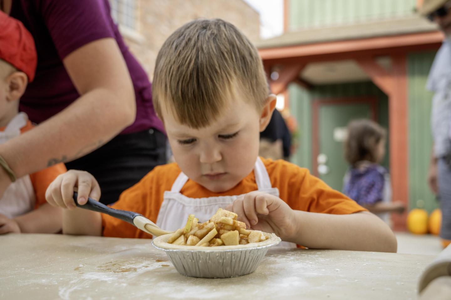 Kid making his own mini apple pie at Davison Orchards