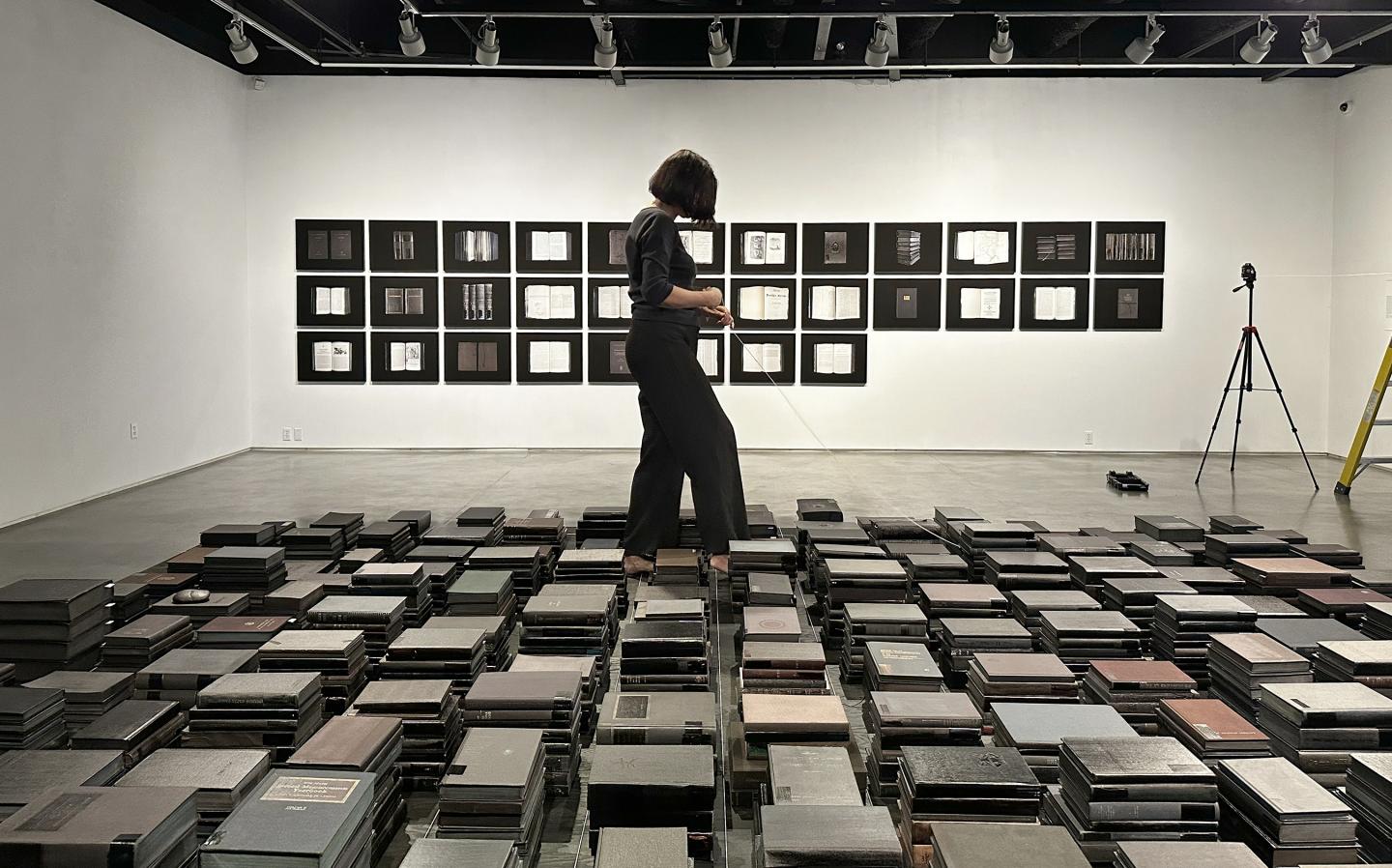 Mary Kavanagh between stacks of books in Opera Obscura