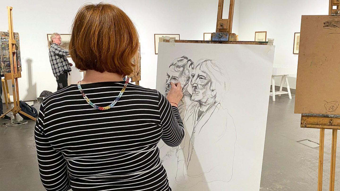 Woman drawing a live model
